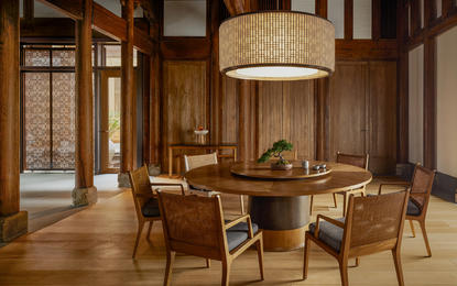 Amanyangyun residence dining room with round wooden table, upholstered chairs, and pendant lighting.