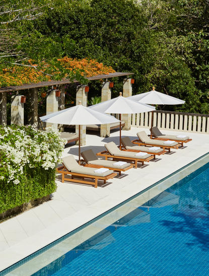 Six-bedroom villa at Aman Villas at Nusa Dua with swimming pool, sun loungers, and terraced gardens.