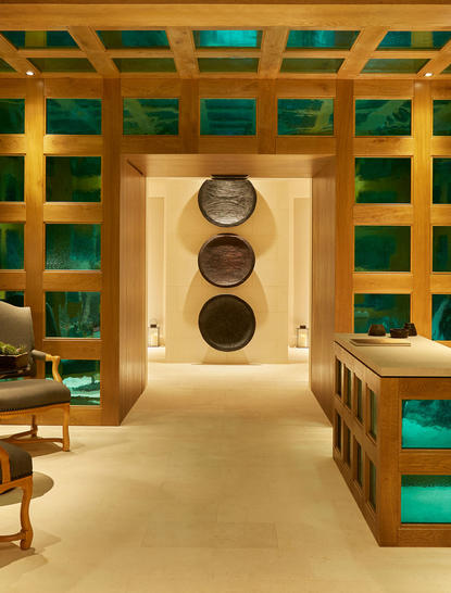 Spa treatment room at Aman Le Mélézin with turquoise and timber lattice walls and stone massage beds.
