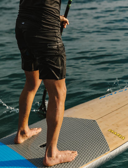 宾客在安缦湾澜度假村的码头上站在蓝色滑板上，准备水上活动。