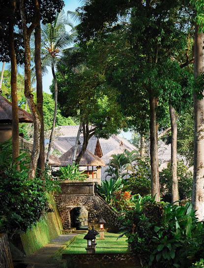 Two-bedroom suite at Amandari resort, framed by tall trees with stone pathways and manicured gardens.