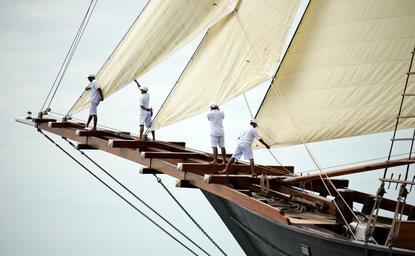 安缦湾澜度假村的帆船船头和船员，展示传统木制帆船的细节。