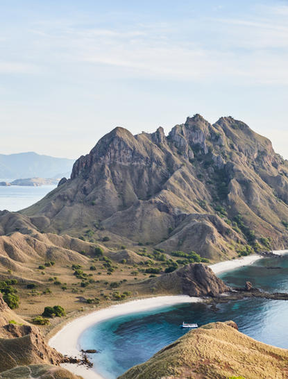 Rugged volcanic peaks rise above turquoise waters at Amandira, Komodo, Indonesia.