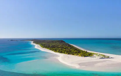 Amanpulo resort island with white sand beach and turquoise waters.