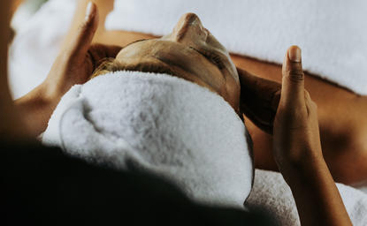 Serviettes blanches pliées sur un plateau en bois à Amanpuri.