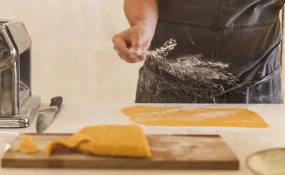 Tavolo da pranzo presso il resort Amanpuri con bottiglia di vino e tagliere di legno.