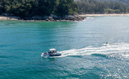 Speedboat skimming turquoise waters at Amanpuri resort's watersports centre.