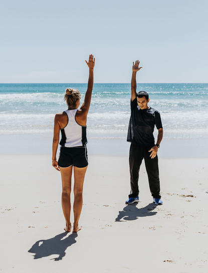 Dos atletas en la playa de Amanpuri resort, preparados para entrenar junto al mar.