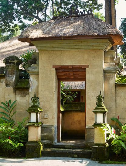 Cream-coloured stone pool suite entrance at Amandari, with wooden door and climbing ivy.
