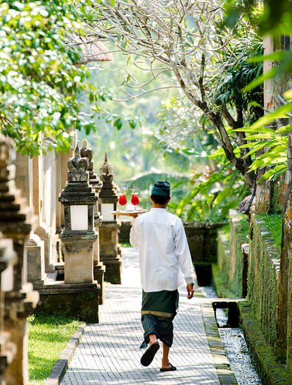 アマンダリ リゾートの谷間スイートへ向かう、緑に囲まれた石畳の通路を歩くゲスト。