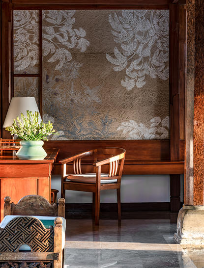 Amandari রিসর্টে একটি গ্রামীণ স্যুটের অভ্যন্তরীণ দৃশ্য, যেখানে কাঠের আসবাবপত্র এবং শোভাকর বৃক্ষরাজি রয়েছে।