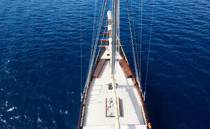 Sailing yacht's bow extending into deep blue waters at Amandira.