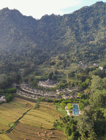 Amanjiwo resort nestled amongst forested hills and rice paddies, aerial view, Indonesia.