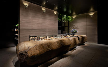 アマン東京のラ・パティスリーで、木製の大型パン型の装置が照明に照らされている空間。