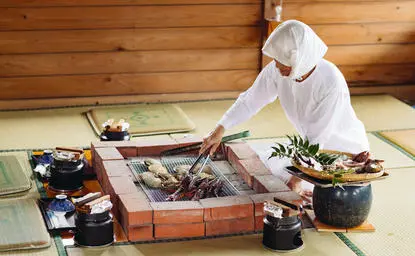 アマネム リゾートでの日本料理の調理風景。シェフが木製のカウンターで新鮮な食材を準備している。