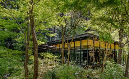 アマン東京のカフェ、樹木に囲まれた黄色い建物の外観。
