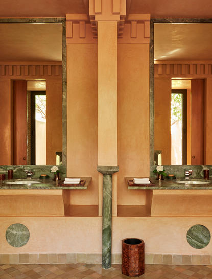 アマンジェナ リゾートの宿泊パビリオン、対称的な柱と温かみのあるテラコッタ色の壁が特徴。