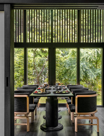 安缦京都度假村的私人餐厅，圆形餐桌前有大窗户和传统木质屏风。