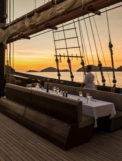 Amandira's terrace bench overlooking golden sunset over water at dusk.