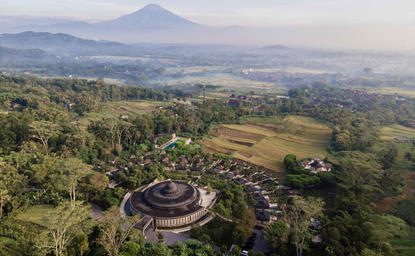Aerial view of Amankila's circular architecture nestled within lush volcanic landscape, Bali.