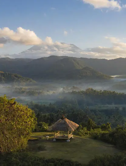 Sunrise breakfast view over misty valleys at Amankila resort, Bali.
