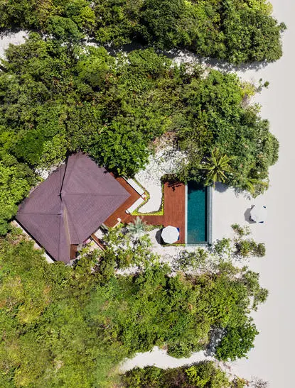 安缦璞乐度假村海滩泳池别墅，俯瞰图显示紫色屋顶建筑、游泳池和翠绿植被。