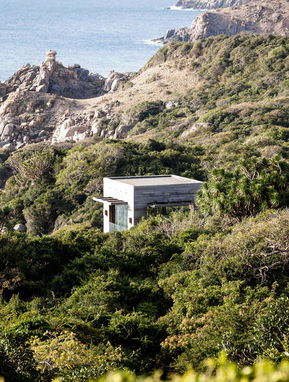 Amanoi pavilion nestled amongst verdant hillside landscape, Vietnam resort.