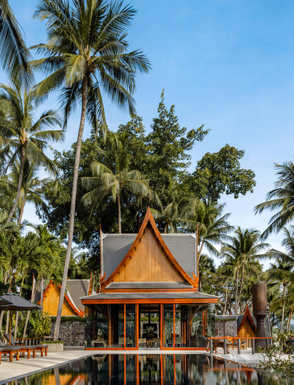 安缦璞瑞度假村内，金色屋顶的泰式寺庙建筑矗立在棕榈树环绕的庭园中。