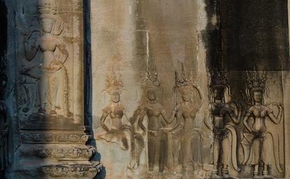 Carved stone relief depicting figures in traditional Cambodian dress at Amansara.