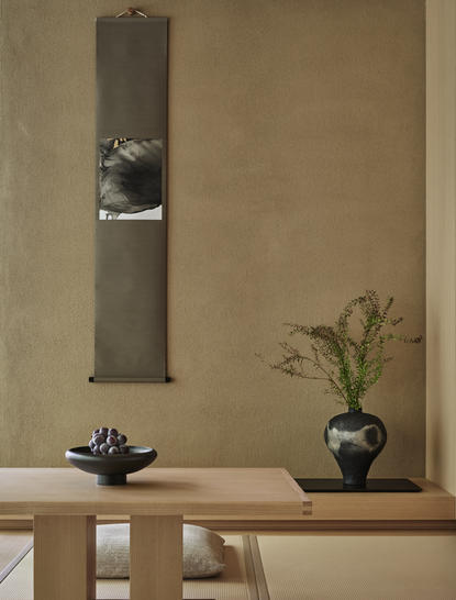 Pavilion room with wooden table, ceramic vessels, and vertical wall-mounted artwork at Aman Kyoto.