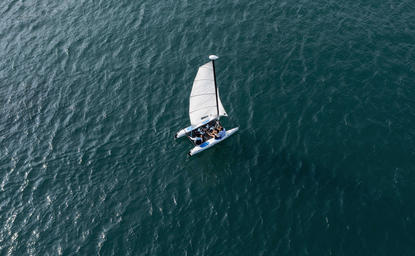 Aerial view of a white sailing yacht on turquoise waters at Amanoi.