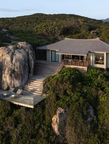 Ocean pavilion at Amanoi perched on a clifftop overlooking forested coastline at dusk.