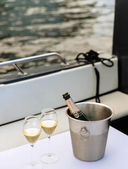 Deux verres de champagne et un seau à glace sur une table avec vue sur l'eau à Aman Tokyo.