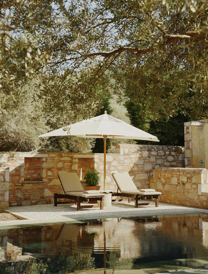 Garden view pavilion with plunge pool at Amanruya, featuring white canvas canopy and wooden seating.