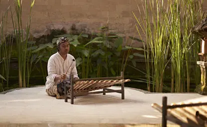 Instructor demonstrating rindik bamboo percussion technique during a class at Amandari, Indonesia.