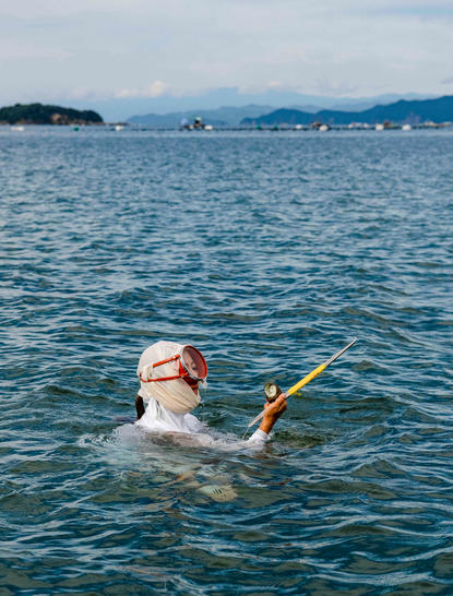 安缦伊沐度假村的海女在清澈海水中潜水采珍珠。