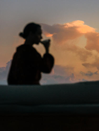 Silhouette of a photographer capturing sunset clouds at Amanyara resort.
