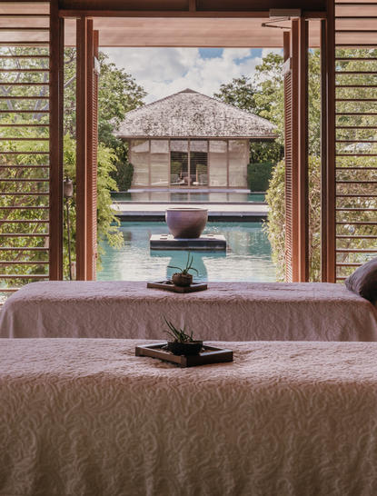 Spa pavilion viewed through open doors at Amanyara resort, with reflecting pool and tropical vegetation.