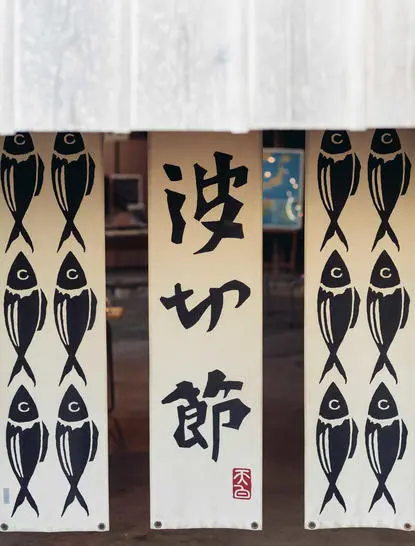 Amanemu リゾートの伝統的な日本の装飾パネル。中央に漢字、両側に幾何学模様の黒白デザイン。