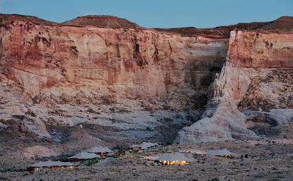 安缦奇岭度假村营地鸟瞰图，红色岩层峡谷中可见蜿蜒溪流。