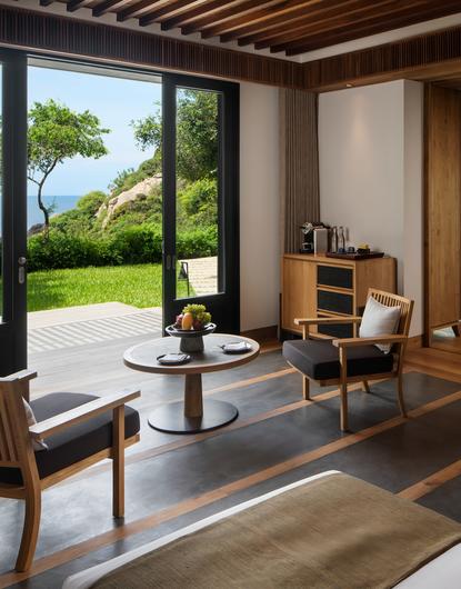 安缦诺怡度假村初级卧室，落地窗外可见海景和花园。