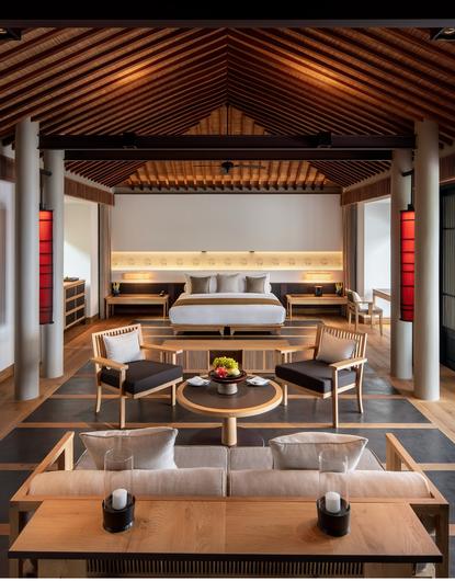 安缦诺怡度假村海景泳池别墅的主卧室，设有木质天花板和现代家具。