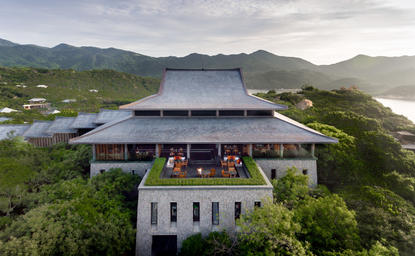 安缦诺怡度假村的中央亭阁，俯瞰山景和海岸线的建筑全景。