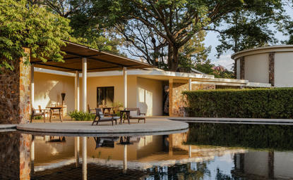 Amansara's wooden pavilion reflected in still water at dusk, Cambodia.
