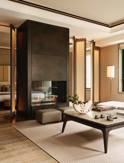 Corner Suite at Aman New York with fireplace, wooden accents, and minimalist furnishings.