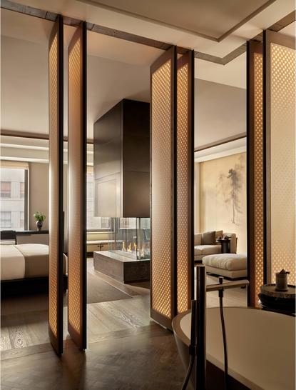 アマン ニューヨークのグランドスイート57丁目の寝室入口。木製フレームのドアが開かれ、奥の空間が見える。