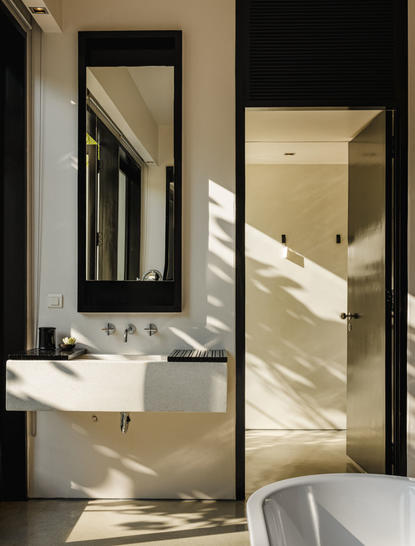 Principal bathroom at Amansara with dual vanity and natural light streaming through open doors.