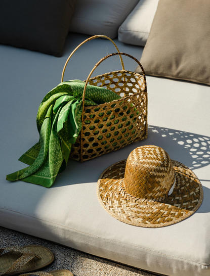 Woven basket and straw hat with green silk scarf at Amansara, Cambodia.