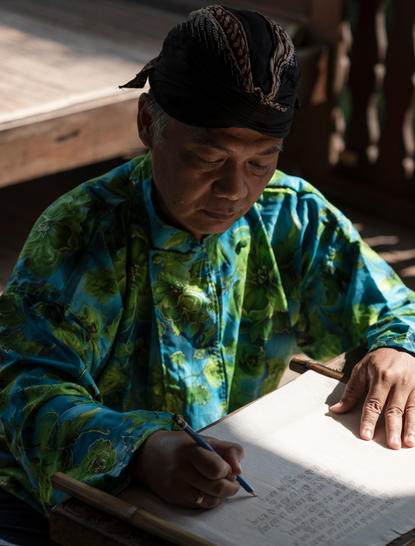 Artisan demonstrating Aksara Jawa script writing at Amanjiwo resort, Central Java.