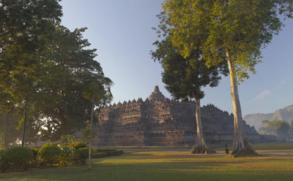 Borobudur Temple with manicured grounds and tall trees at Amanjiwo resort, Java.